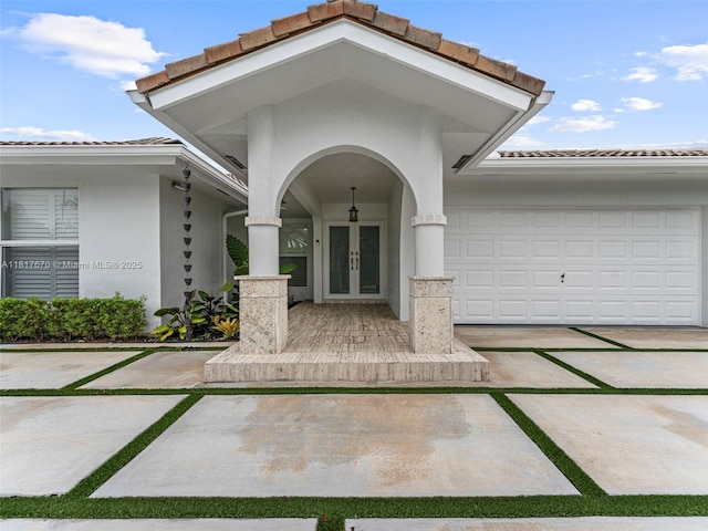 5976 SW 88th Pl, Miami, FL 33173 - property entrance featuring french doors, a tile roof, stucco siding, driveway, and a garage