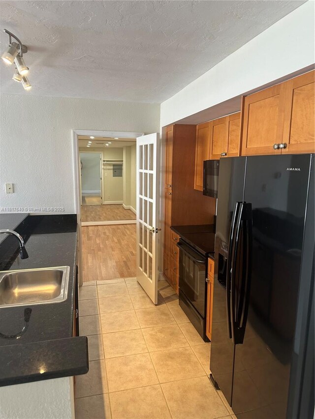 10350 W Bay Harbor Dr Unit 4F, Bay Harbor Islands, FL 33154 - kitchen with black appliances, dark countertops, brown cabinetry, french doors, and a textured ceiling