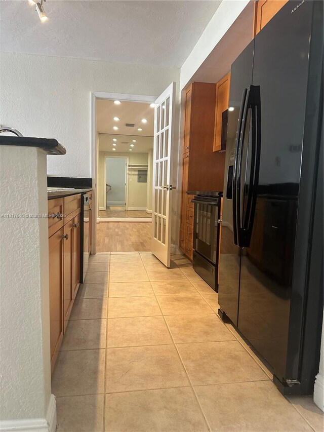 10350 W Bay Harbor Dr Unit 4F, Bay Harbor Islands, FL 33154 - kitchen with black appliances, french doors, brown cabinetry, a textured wall, and light tile patterned floors