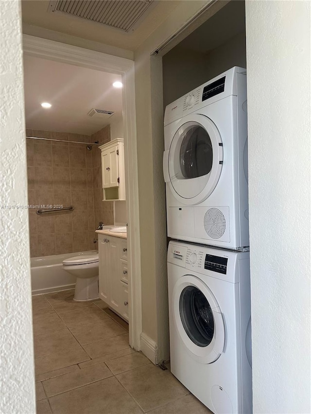 10350 W Bay Harbor Dr Unit 4F, Bay Harbor Islands, FL 33154 - laundry room featuring stacked washer / drying machine and light tile patterned flooring