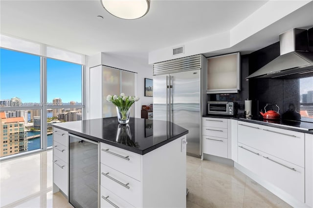 1331 Brickell Bay Dr Unit 4001, Miami, FL 33131 - kitchen featuring wine cooler, wall chimney exhaust hood, built in fridge, modern cabinets, and dark countertops
