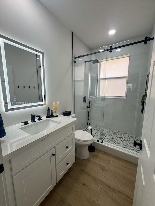 7714 NW 70th Way, Parkland, FL 33067 - bathroom featuring vanity, wood finished floors, a stall shower, and recessed lighting