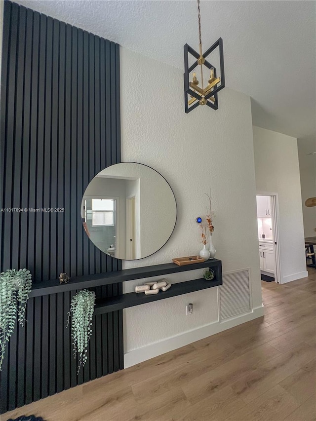7714 NW 70th Way, Parkland, FL 33067 - hallway featuring wood finished floors and a chandelier