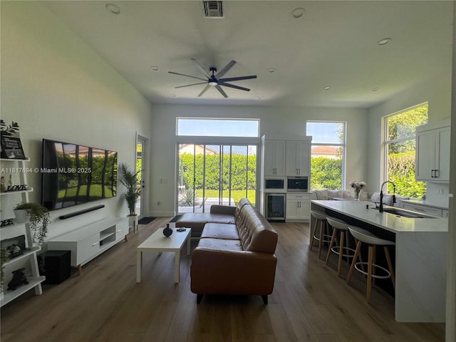 7714 NW 70th Way, Parkland, FL 33067 - living room featuring a ceiling fan, wood finished floors, plenty of natural light, beverage cooler, and recessed lighting