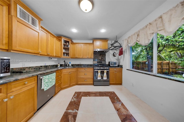 81 Hough Dr, Miami Springs, FL 33166 - kitchen with stainless steel appliances, glass insert cabinets, recessed lighting, brown cabinets, and inlaid floor details