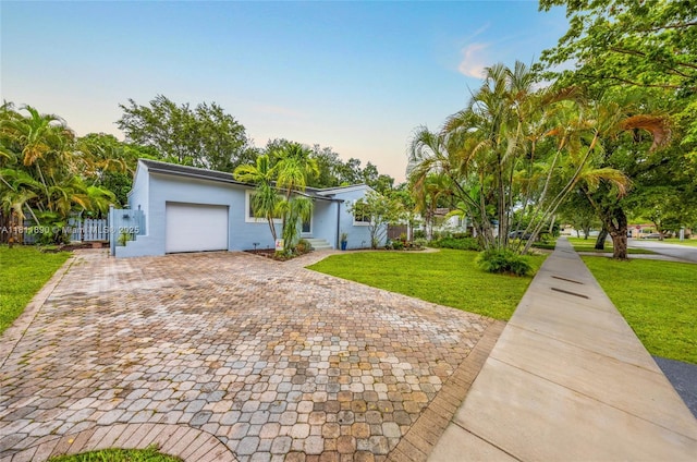81 Hough Dr, Miami Springs, FL 33166 - view of front of house featuring an attached garage, a yard, stucco siding, and decorative driveway