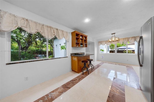 81 Hough Dr, Miami Springs, FL 33166 - kitchen featuring open shelves, inlaid floor details, freestanding refrigerator, a chandelier, and dark countertops