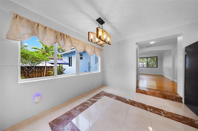 81 Hough Dr, Miami Springs, FL 33166 - unfurnished dining area with inlaid floor details, tile patterned floors, and a chandelier