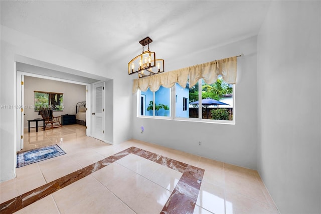 81 Hough Dr, Miami Springs, FL 33166 - unfurnished dining area featuring tile patterned flooring, a chandelier, and inlaid floor details