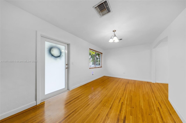 81 Hough Dr, Miami Springs, FL 33166 - spare room with a chandelier and light wood-style flooring