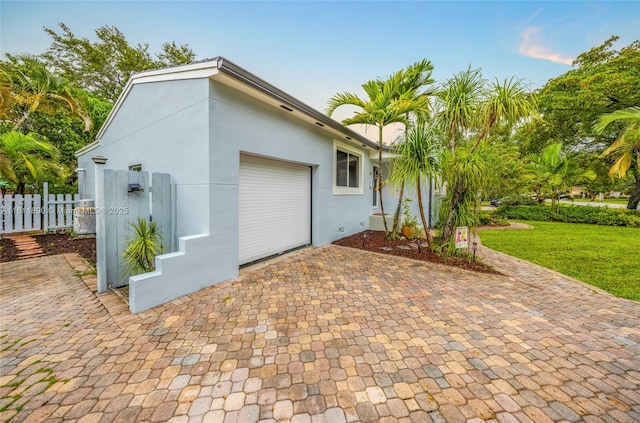 81 Hough Dr, Miami Springs, FL 33166 - view of property exterior with an attached garage, stucco siding, and decorative driveway