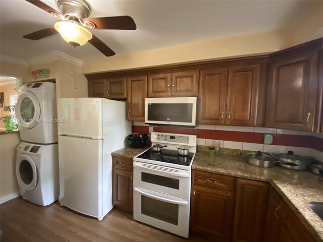 6200 NW 44th St Unit 115, Lauderhill, FL 33319 - kitchen featuring white appliances, stacked washer and clothes dryer, ceiling fan, crown molding, and wood finished floors