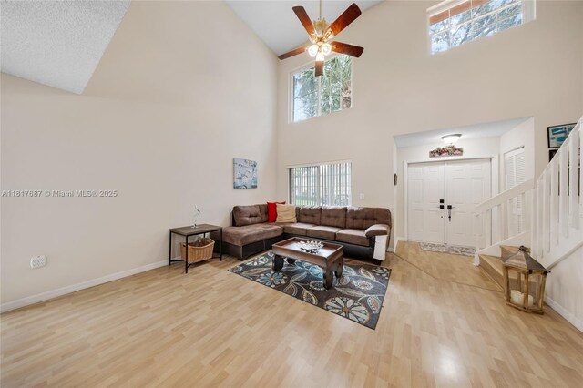 13344 NW 7th St, Plantation, FL 33325 - living area featuring high vaulted ceiling, light wood-type flooring, stairway, a ceiling fan, and baseboards