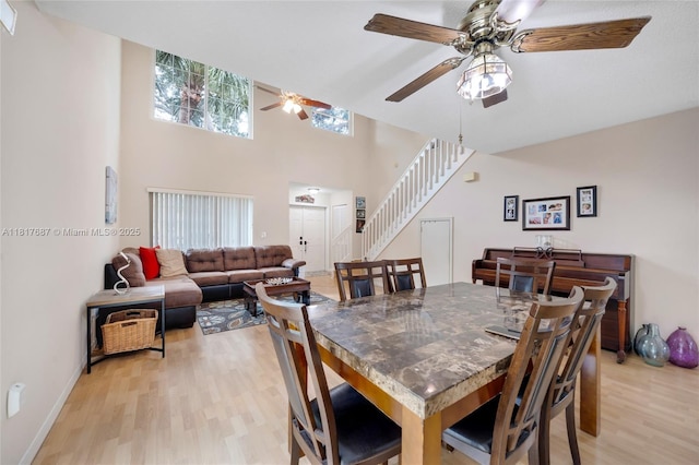 13344 NW 7th St, Plantation, FL 33325 - dining room featuring light wood-style flooring, a ceiling fan, stairway, a high ceiling, and baseboards