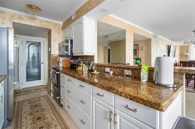 250 174th St Unit 1704, Sunny Isles Beach, FL 33160 - kitchen with stainless steel appliances, light tile patterned floors, dark countertops, ornamental molding, and white cabinets
