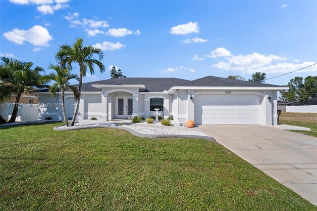4524 SW 9th Pl, Cape Coral, FL 33914 - ranch-style home with french doors, stucco siding, a front yard, a garage, and driveway
