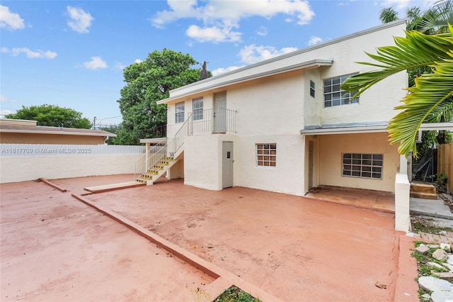 2385 SW 17th St, Miami, FL 33145 - back of property featuring stucco siding, a patio area, and stairway