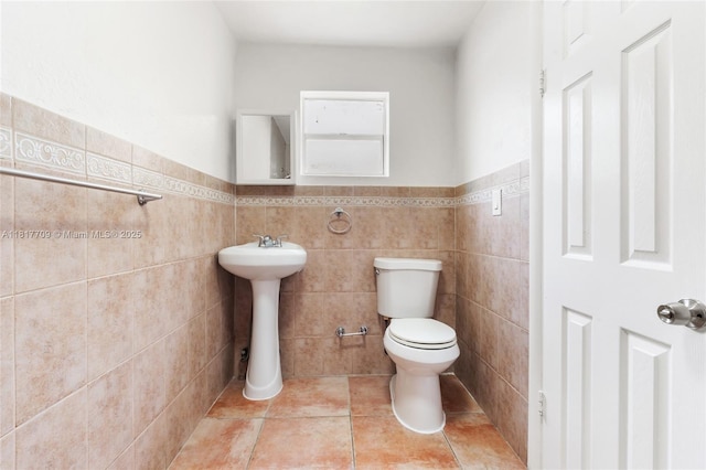 2385 SW 17th St, Miami, FL 33145 - half bath featuring toilet, tile patterned floors, tile walls, a sink, and a wainscoted wall