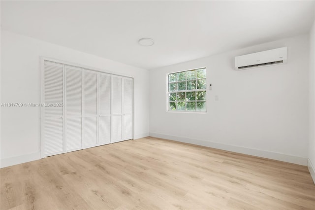 2385 SW 17th St, Miami, FL 33145 - unfurnished bedroom with a wall unit AC, wood finished floors, a closet, and baseboards