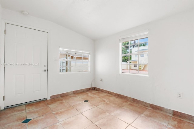 2385 SW 17th St, Miami, FL 33145 - empty room featuring vaulted ceiling, baseboards, light tile patterned floors, and a smoke detector