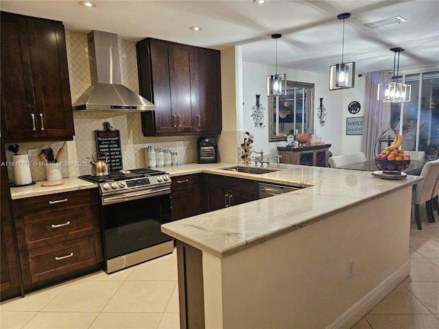 10270 NW 46th St, Doral, FL 33178 - kitchen with gas stove, wall chimney range hood, a sink, light tile patterned floors, and a peninsula
