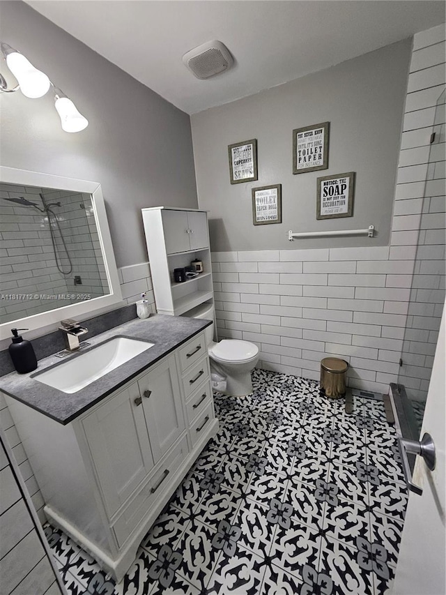 10270 NW 46th St, Doral, FL 33178 - full bathroom with tile walls, toilet, vanity, tiled shower, and wainscoting