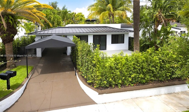 326 SW 20th Rd, Miami, FL 33129 - view of front of home featuring a carport, stucco siding, metal roof, a standing seam roof, and concrete driveway