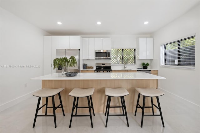 326 SW 20th Rd, Miami, FL 33129 - kitchen with appliances with stainless steel finishes, a kitchen breakfast bar, white cabinetry, light countertops, and recessed lighting