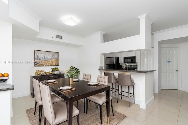 17125 N Bay Rd Unit 3104, Sunny Isles Beach, FL 33160 - dining space featuring ornamental molding, light tile patterned flooring, and baseboards