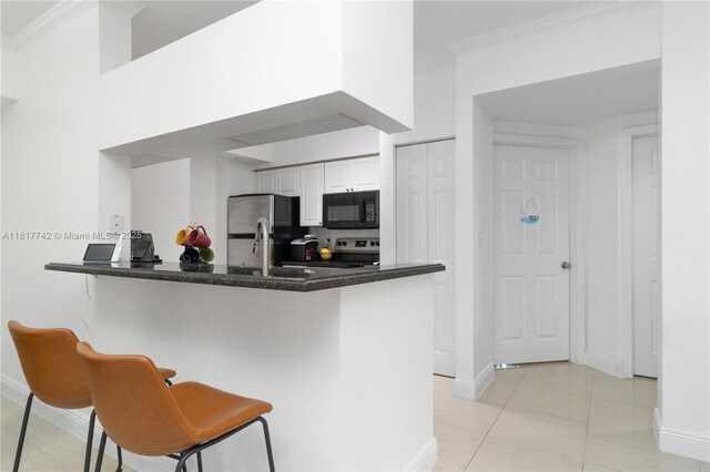 17125 N Bay Rd Unit 3104, Sunny Isles Beach, FL 33160 - kitchen with black microwave, range, crown molding, freestanding refrigerator, and baseboards