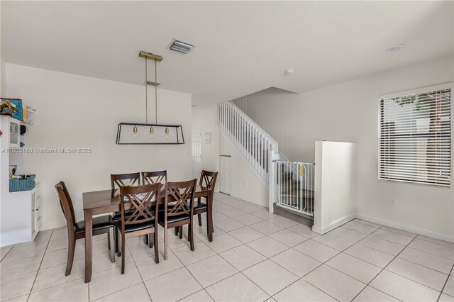 10625 W 32nd Ln, Hialeah, FL 33018 - dining area with light tile patterned floors, stairway, and baseboards