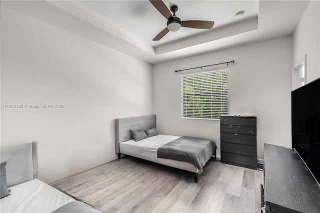 10625 W 32nd Ln, Hialeah, FL 33018 - bedroom featuring wood finished floors, a tray ceiling, and ceiling fan