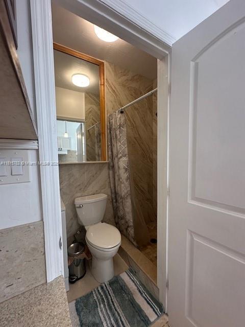 300 NW 77th Way, Pembroke Pines, FL 33024 - full bathroom featuring toilet, a shower stall, and tile walls