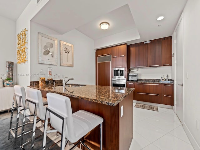 15901 Collins Ave Unit 403, Sunny Isles Beach, FL 33160 - kitchen with paneled built in refrigerator, a kitchen bar, a sink, modern cabinets, and recessed lighting