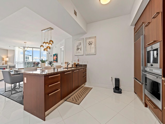 15901 Collins Ave Unit 403, Sunny Isles Beach, FL 33160 - kitchen featuring dark stone counters, a peninsula, modern cabinets, open floor plan, and pendant lighting