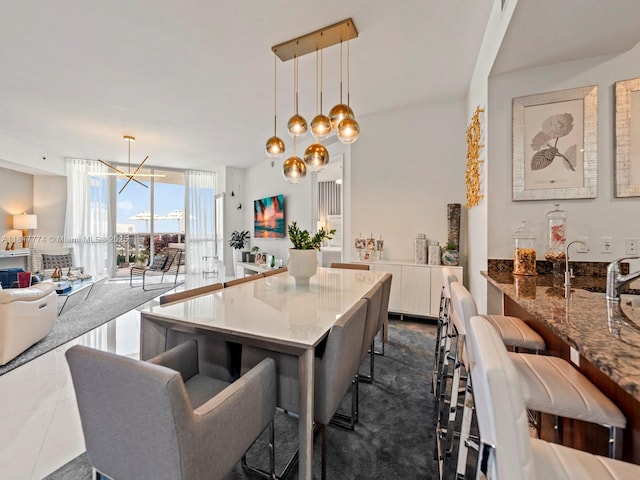 15901 Collins Ave Unit 403, Sunny Isles Beach, FL 33160 - kitchen with a breakfast bar area, a chandelier, stone countertops, floor to ceiling windows, and white cabinets