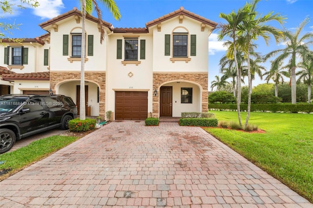 232 SE 33rd Ter, Homestead, FL 33033 - mediterranean / spanish house with stucco siding, decorative driveway, stone siding, a garage, and a front lawn