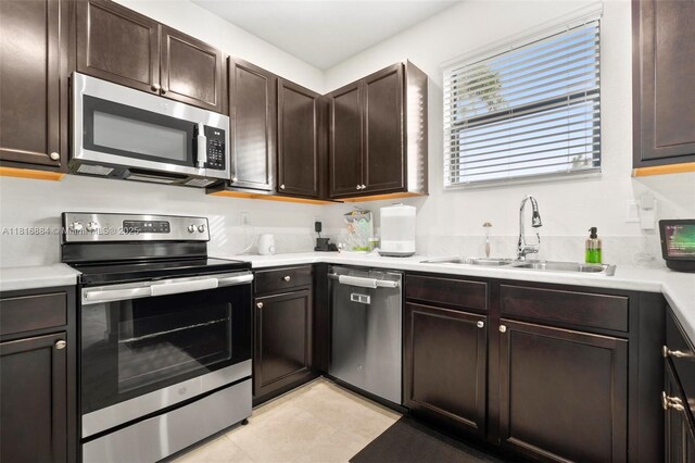 232 SE 33rd Ter, Homestead, FL 33033 - kitchen featuring appliances with stainless steel finishes, a sink, dark brown cabinets, and light countertops