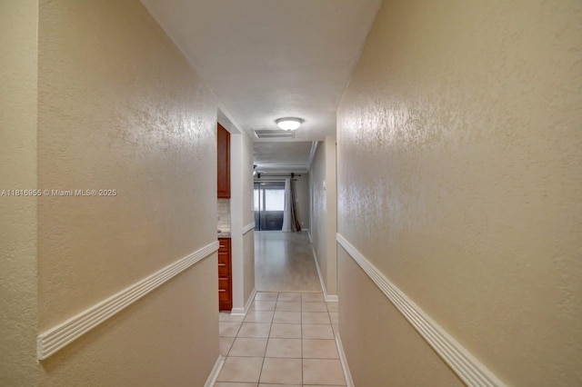 10 Seville Cir Unit 6-54, Davie, FL 33324 - hallway featuring light tile patterned floors, a textured wall, and baseboards