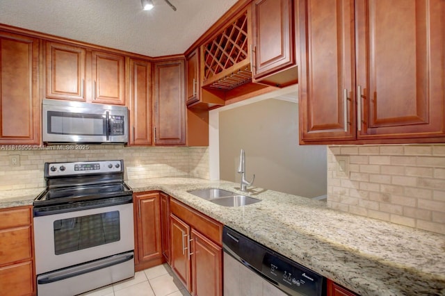 10 Seville Cir Unit 6-54, Davie, FL 33324 - kitchen featuring stainless steel appliances, a sink, light stone counters, backsplash, and a textured ceiling