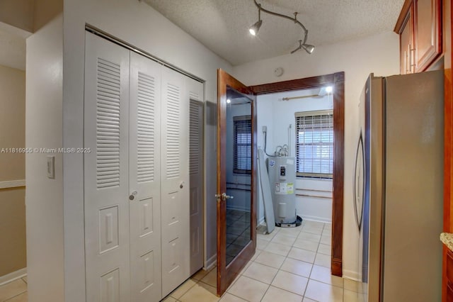 10 Seville Cir Unit 6-54, Davie, FL 33324 - hallway featuring electric water heater, light tile patterned flooring, a textured ceiling, and track lighting