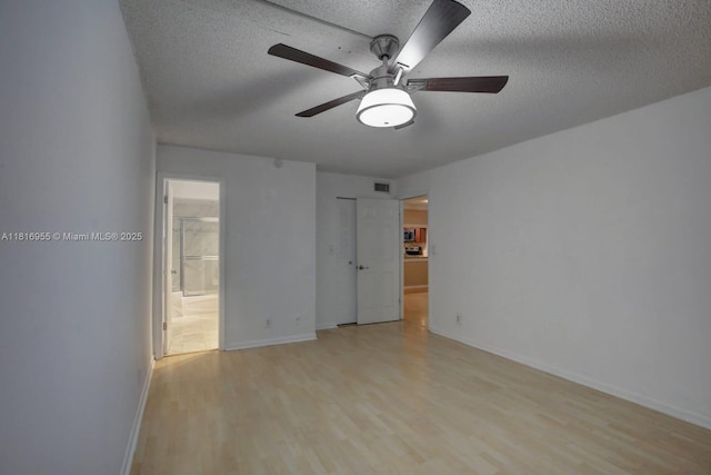 10 Seville Cir Unit 6-54, Davie, FL 33324 - unfurnished bedroom with light wood-style flooring, a textured ceiling, baseboards, ensuite bath, and a ceiling fan