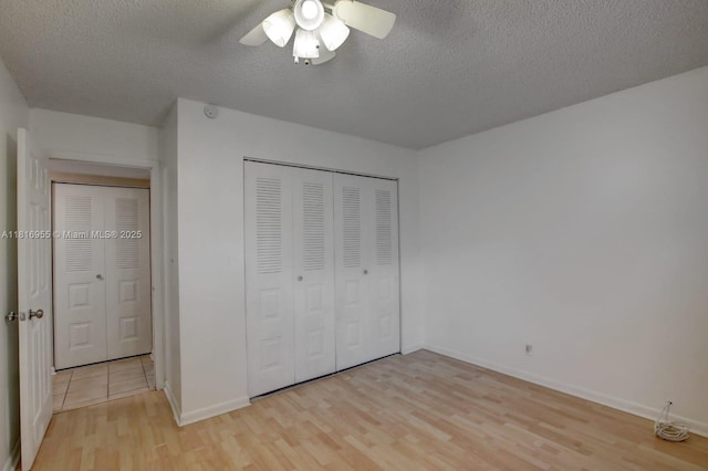 10 Seville Cir Unit 6-54, Davie, FL 33324 - unfurnished bedroom with light wood-style floors, a textured ceiling, a closet, baseboards, and a ceiling fan