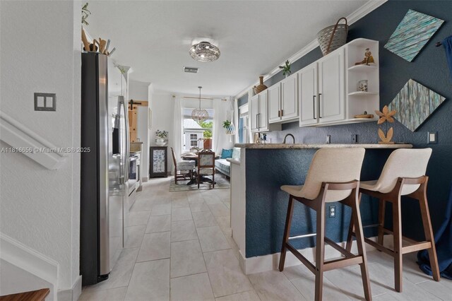 402 SE 30th Ter, Homestead, FL 33033 - kitchen with stainless steel refrigerator with ice dispenser, white cabinetry, open shelves, a kitchen bar, and a peninsula