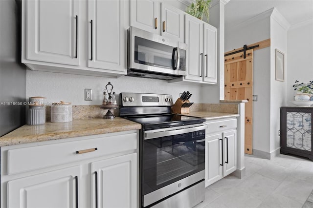 402 SE 30th Ter, Homestead, FL 33033 - kitchen featuring appliances with stainless steel finishes, ornamental molding, light tile patterned flooring, white cabinets, and a barn door
