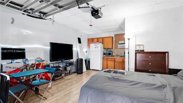 3145 Hollywood Blvd, Hollywood, FL 33021 - bedroom featuring freestanding refrigerator, a paneled ceiling, light wood finished floors, and a garage