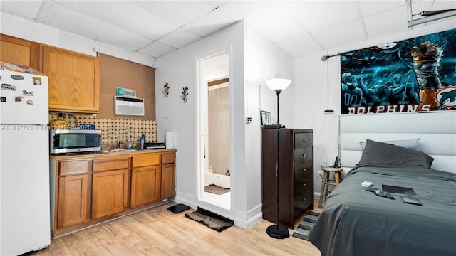 3145 Hollywood Blvd, Hollywood, FL 33021 - bedroom with freestanding refrigerator, a paneled ceiling, light wood-type flooring, and a wall unit AC