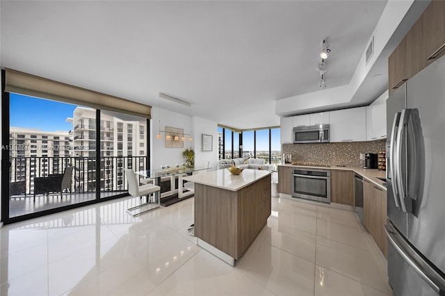 5252 NW 85th Ave Unit 1701, Doral, FL 33166 - kitchen featuring stainless steel appliances, modern cabinets, backsplash, a kitchen island, and a wall of windows