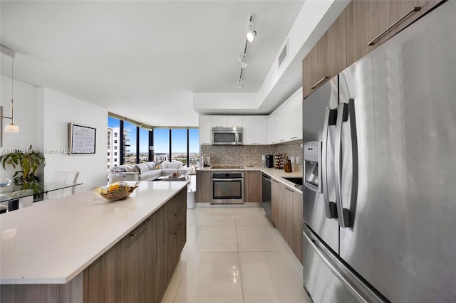 5252 NW 85th Ave Unit 1701, Doral, FL 33166 - kitchen with stainless steel appliances, modern cabinets, light countertops, light tile patterned floors, and backsplash