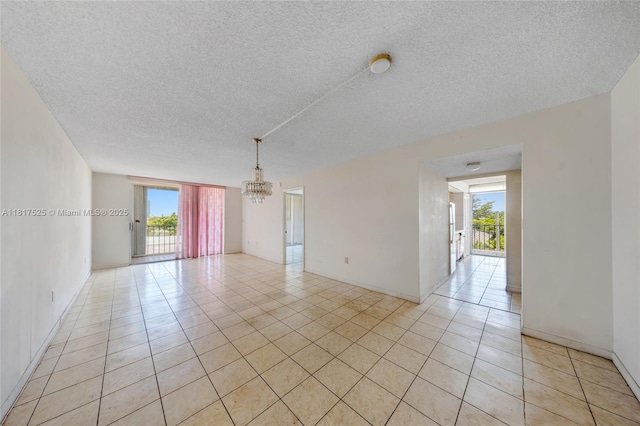 7921 Byron Ave Unit 407, Miami Beach, FL 33141 - empty room featuring plenty of natural light, light tile patterned floors, a chandelier, a textured ceiling, and baseboards